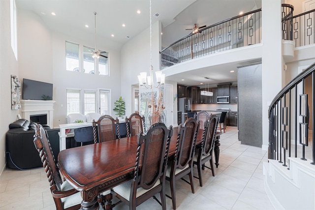 3514 Hampton Landing Ct, Katy, TX 77494 - dining area featuring ceiling fan, a high ceiling, stairway, light tile patterned floors, and a fireplace