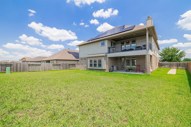 3514 Hampton Landing Ct, Katy, TX 77494 - rear view of house featuring a balcony, roof mounted solar panels, a patio area, a chimney, and stucco siding