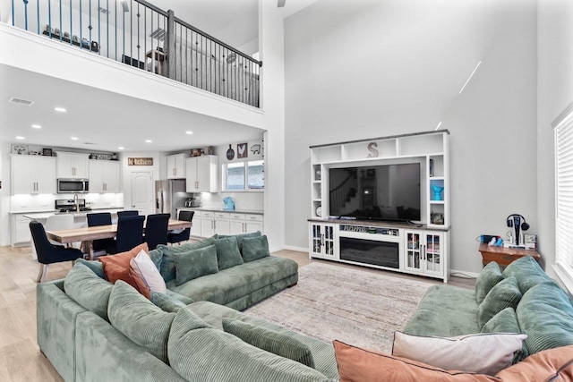 1526 Oakdale Crest Rd, Montgomery, TX 77316 - living room featuring light wood finished floors, healthy amount of natural light, a towering ceiling, recessed lighting, and baseboards