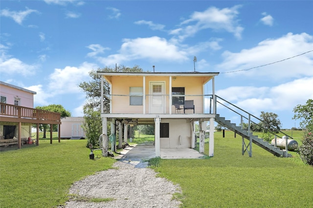 116 Linda St, Anahuac, TX 77514 - rear view of property featuring a carport, driveway, stairway, and a lawn