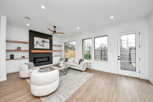5520 Chapman St, Houston, TX 77009 - living room featuring light wood-type flooring, a large fireplace, recessed lighting, a ceiling fan, and baseboards