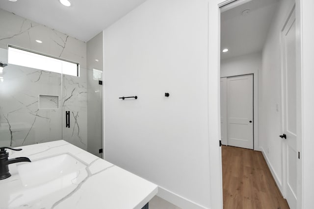 5520 Chapman St, Houston, TX 77009 - bathroom with recessed lighting, a marble finish shower, wood finished floors, baseboards, and a sink