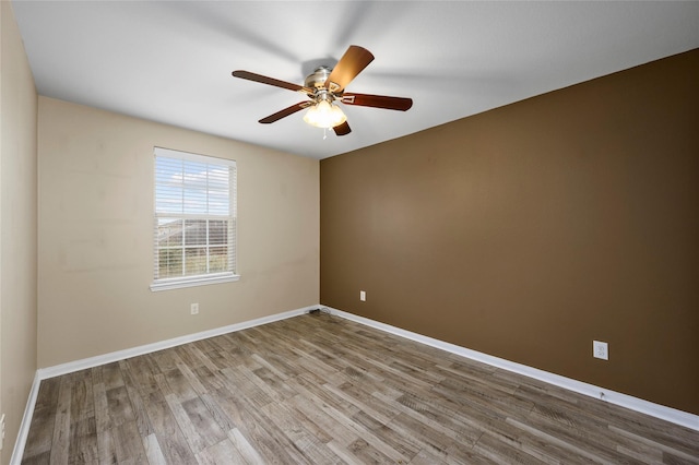unfurnished room with wood finished floors, ceiling fan, and baseboards