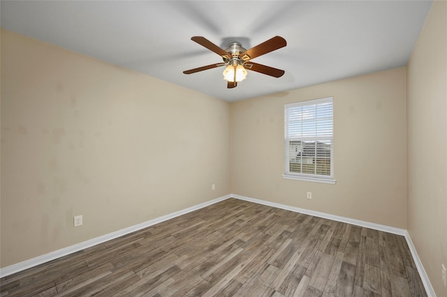 spare room featuring wood finished floors, baseboards, and a ceiling fan