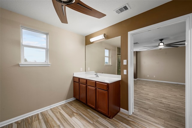 bathroom with a ceiling fan, wood finished floors, and baseboards