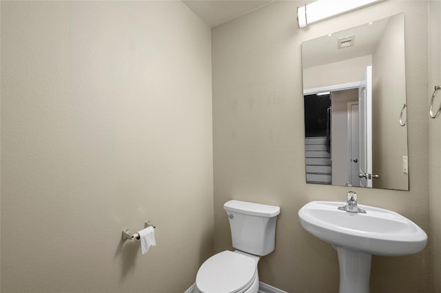 bathroom with toilet and baseboards