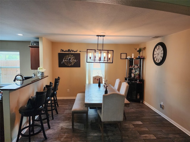 dining area with baseboards, a chandelier, and dark wood-style floors