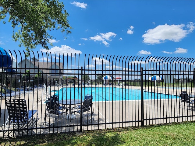 community pool featuring fence and a patio