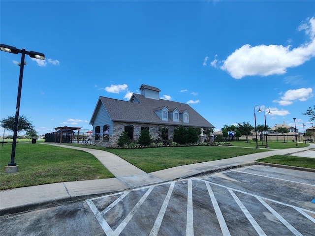 view of property exterior featuring a lawn, uncovered parking, and stone siding