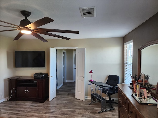 home office featuring dark wood-style flooring, a ceiling fan, and baseboards