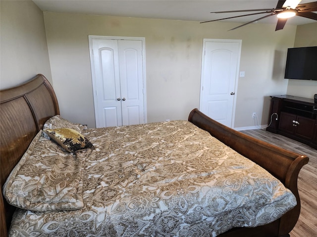bedroom with wood finished floors, a closet, a ceiling fan, and baseboards