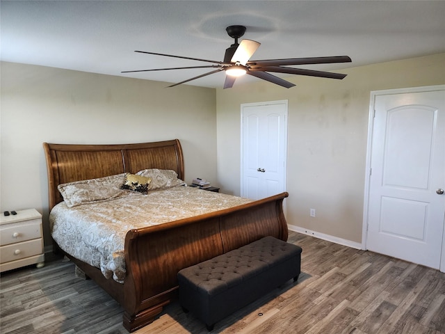 bedroom with wood finished floors, a ceiling fan, and baseboards