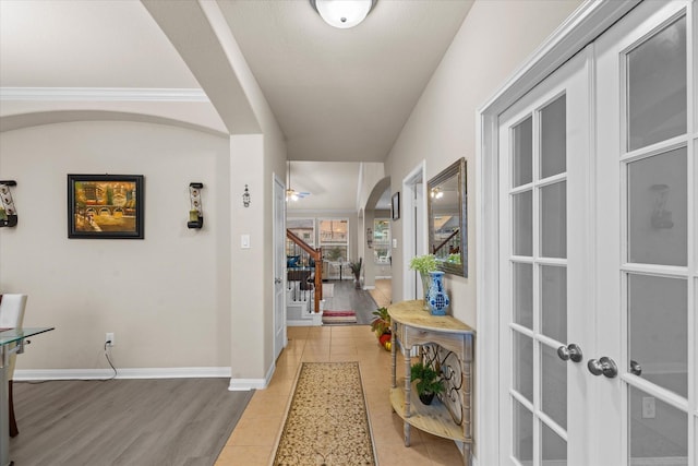 4603 Tamara Heights Ln, Sugar Land, TX 77479 - hallway featuring arched walkways, light tile patterned floors, stairs, and baseboards