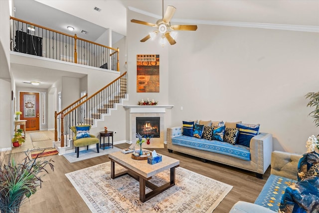 4603 Tamara Heights Ln, Sugar Land, TX 77479 - living area featuring a towering ceiling, stairs, wood finished floors, a ceiling fan, and crown molding