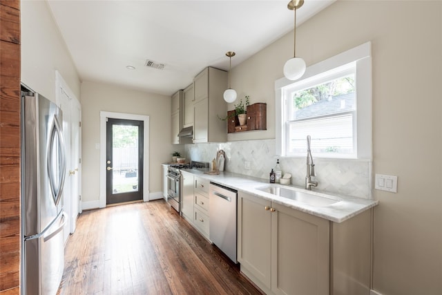 108 E 27th St, Houston, TX 77008 - kitchen with stainless steel appliances, a sink, tasteful backsplash, light wood finished floors, and under cabinet range hood