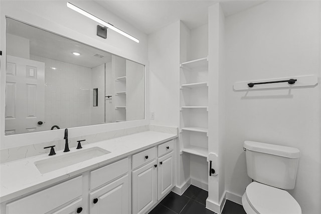 bathroom with toilet, tile patterned floors, vanity, baseboards, and a shower