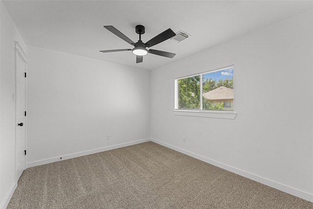 spare room with carpet, a ceiling fan, and baseboards