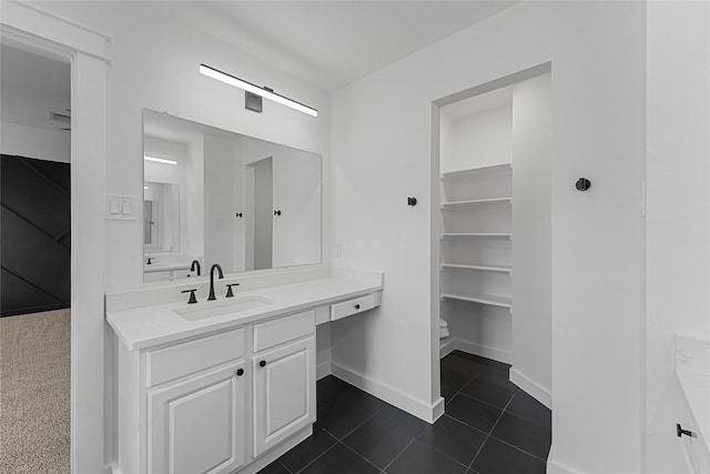 bathroom with baseboards, vanity, tile patterned floors, and toilet