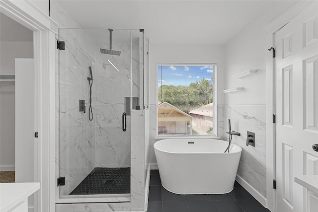 full bath with a marble finish shower, a freestanding tub, vanity, and a wainscoted wall