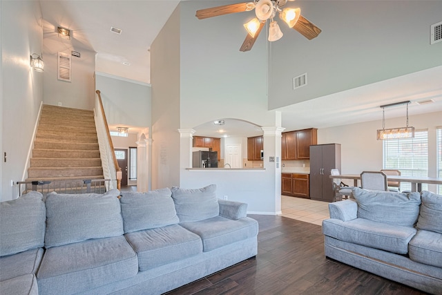 2202 Megellan Point Ln, Pearland, TX 77584 - living room with a ceiling fan, a high ceiling, ornate columns, healthy amount of natural light, and wood finished floors