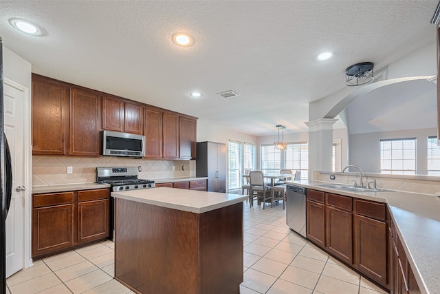 2202 Megellan Point Ln, Pearland, TX 77584 - kitchen with stainless steel appliances, a sink, light tile patterned floors, backsplash, and light countertops