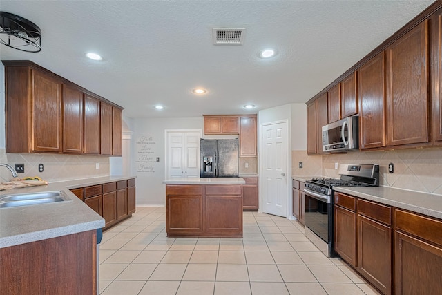 2202 Megellan Point Ln, Pearland, TX 77584 - kitchen with stainless steel appliances, a sink, decorative backsplash, light tile patterned floors, and recessed lighting