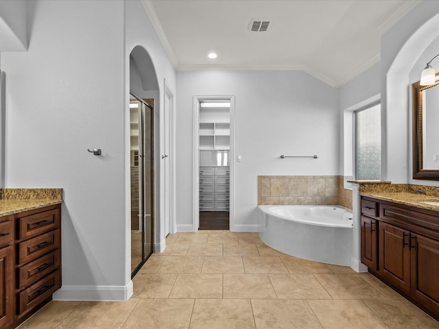 913 Ember Hills Ln, Friendswood, TX 77546 - bathroom with crown molding, a garden tub, vanity, tile patterned flooring, and a walk in closet