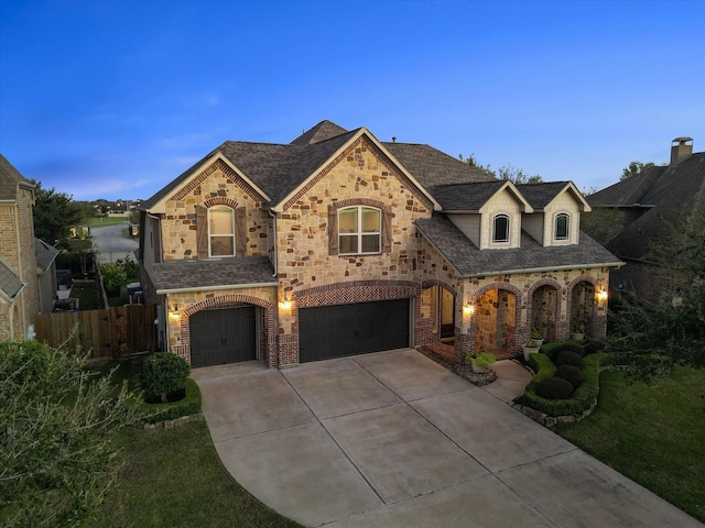 913 Ember Hills Ln, Friendswood, TX 77546 - french country inspired facade featuring driveway, an attached garage, fence, stone siding, and brick siding