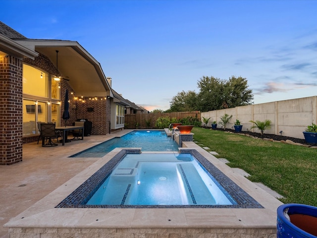 913 Ember Hills Ln, Friendswood, TX 77546 - pool at dusk featuring a patio area and a pool with connected hot tub
