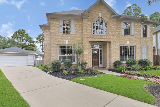 22802 Pennyrile Ln, Katy, TX 77450 - georgian-style home featuring brick siding, a front lawn, and a detached garage