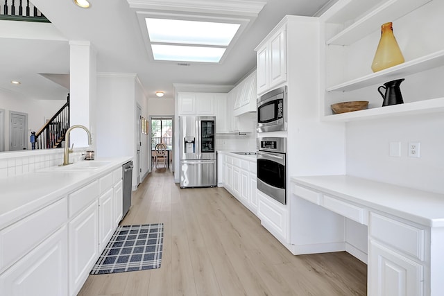 22802 Pennyrile Ln, Katy, TX 77450 - kitchen featuring stainless steel appliances, open shelves, a sink, light wood-type flooring, and white cabinets