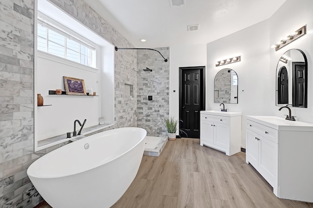 22802 Pennyrile Ln, Katy, TX 77450 - full bathroom with a shower stall, a freestanding bath, wood finished floors, and two vanities