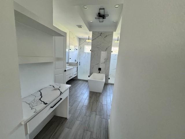 409 Rd 66111, Dayton, TX 77535 - bathroom with a marble finish shower, wood finished floors, vanity, a freestanding bath, and recessed lighting