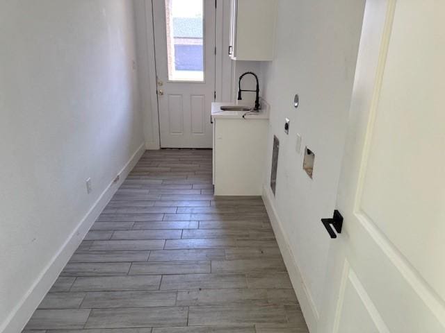409 Rd 66111, Dayton, TX 77535 - washroom with light wood-type flooring, baseboards, and cabinet space