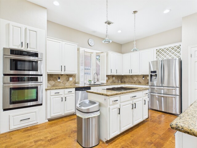 4210 Rock Springs Dr, Houston, TX 77345 - kitchen with stainless steel appliances, a sink, backsplash, a kitchen island, and white cabinets