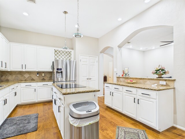 4210 Rock Springs Dr, Houston, TX 77345 - kitchen with stainless steel refrigerator with ice dispenser, arched walkways, backsplash, a kitchen island, and light wood-type flooring