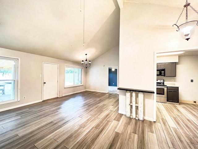 21510 N Tangle Creek Ln, Spring, TX 77388 - unfurnished living room featuring a chandelier, light wood-style floors, baseboards, and high vaulted ceiling