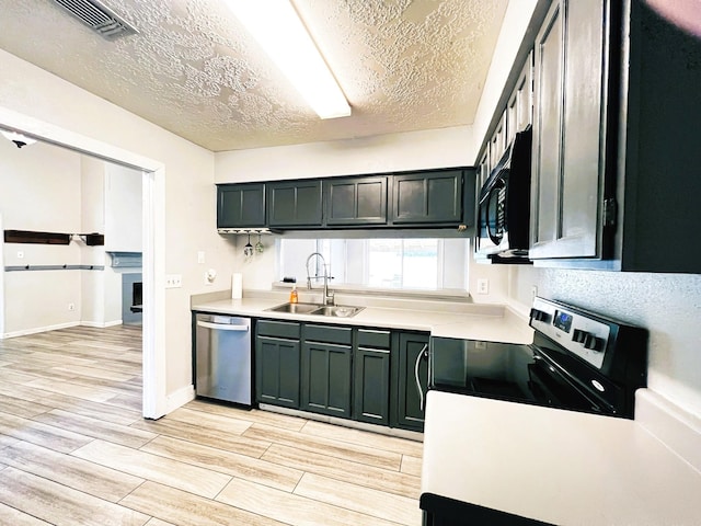 21510 N Tangle Creek Ln, Spring, TX 77388 - kitchen with a sink, appliances with stainless steel finishes, light wood-type flooring, light countertops, and a textured ceiling