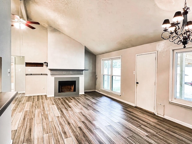 21510 N Tangle Creek Ln, Spring, TX 77388 - unfurnished living room with vaulted ceiling, wood finished floors, a chandelier, ceiling fan, and a fireplace