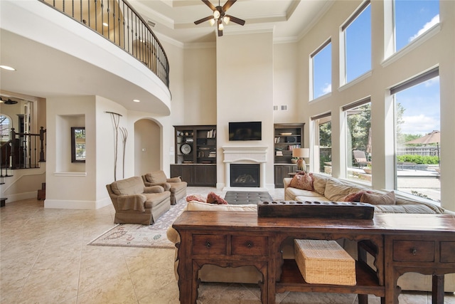 7106 Sentinel Fls, Missouri City, TX 77459 - living area with a ceiling fan, a towering ceiling, baseboards, crown molding, and a fireplace