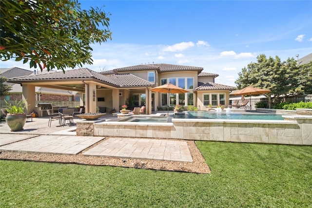 7106 Sentinel Fls, Missouri City, TX 77459 - rear view of house with a patio area, a tiled roof, stucco siding, and a pool with connected hot tub