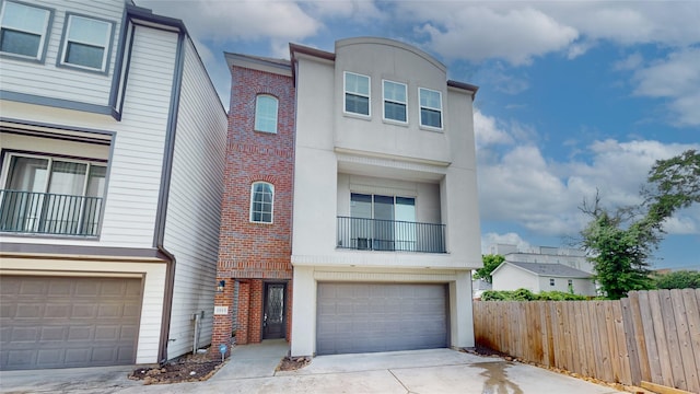1913 Hickory St, Houston, TX 77007 - townhome / multi-family property with brick siding, fence, concrete driveway, and stucco siding