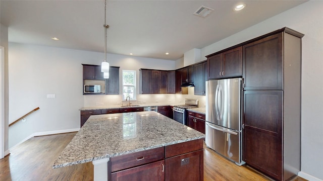 1913 Hickory St, Houston, TX 77007 - kitchen with freestanding refrigerator, range with gas stovetop, white microwave, a sink, and light wood-style flooring