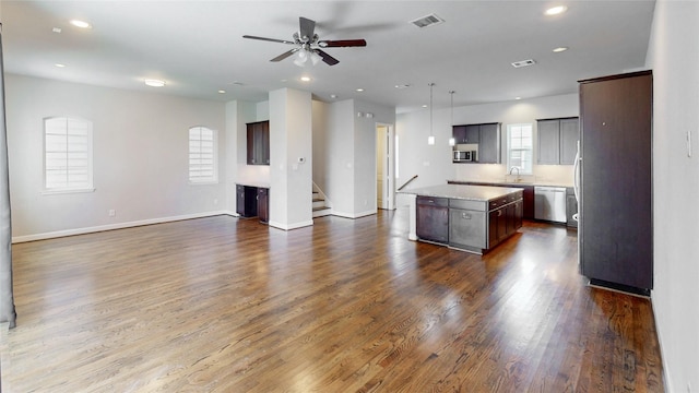 1913 Hickory St, Houston, TX 77007 - kitchen featuring appliances with stainless steel finishes, open floor plan, a center island, a ceiling fan, and dark wood finished floors