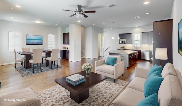 1913 Hickory St, Houston, TX 77007 - living room with wood finished floors, recessed lighting, ceiling fan, baseboards, and stairs