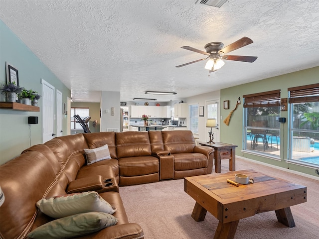 11823 Elizabeth Ct, Pinehurst, TX 77362 - living area with a textured ceiling, ceiling fan, light colored carpet, and healthy amount of natural light