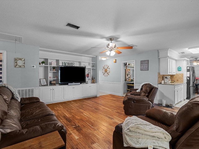 3628 Avenue E 1/2 Ave E 1/2, Santa Fe, TX 77510 - living room featuring ceiling fan, attic access, light wood-style floors, built in shelves, and a wainscoted wall