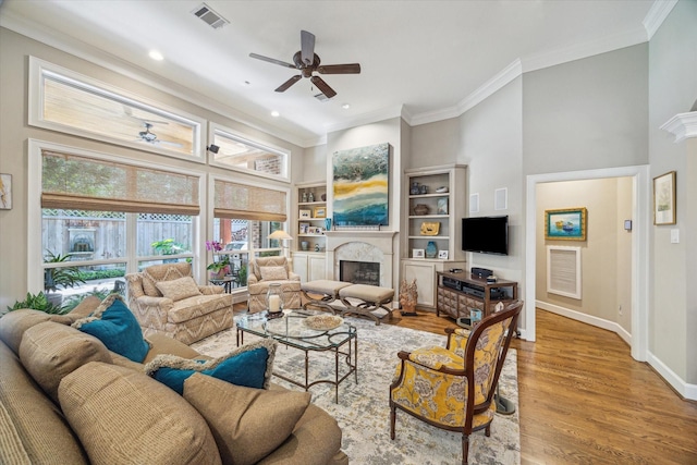 3923 Drake St, Houston, TX 77005 - living room featuring ceiling fan, a fireplace, healthy amount of natural light, crown molding, and light wood-style floors