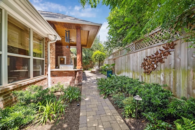 3923 Drake St, Houston, TX 77005 - view of home's exterior with area for grilling, fence, brick siding, a patio, and a shingled roof
