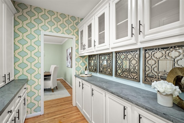 3803 Sunset Blvd, West University Place, TX 77005 - kitchen with wallpapered walls, light wood-type flooring, baseboards, white cabinetry, and glass insert cabinets